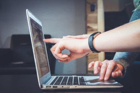 two people reviewing data in a laptop